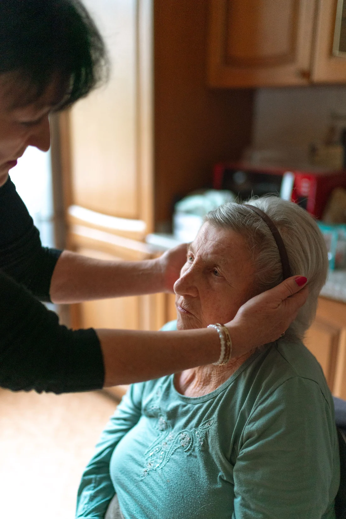 A caregiver helping an older woman at home