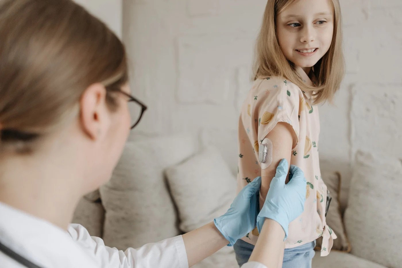 A nurse checking a young girl's blood sugar at home